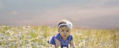 a baby is sitting in the middle of a field