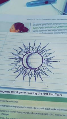 a piece of paper with an image of a sun and moon on it next to a pen