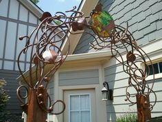 a large metal horse sculpture sitting in front of a house next to a door and window