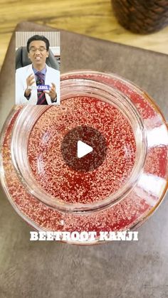 a glass bowl filled with red liquid on top of a wooden table