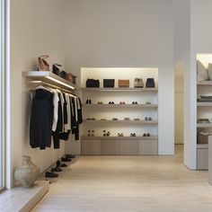 the inside of a clothing store with shelves and shoes