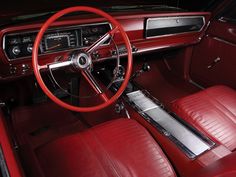 the interior of an old car with red leather seats and steering wheel, including dash board