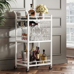 a white bar cart with wine glasses and bottles