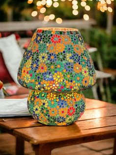 two colorful vases sitting on top of a wooden table