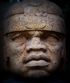 the face of an ancient statue is shown in this image, it appears to be made out of stone