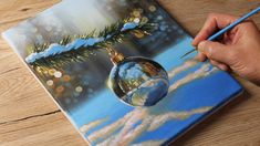 someone is painting a christmas ornament on a canvas