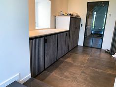 an empty kitchen with tile flooring and cabinets in the corner, next to a door