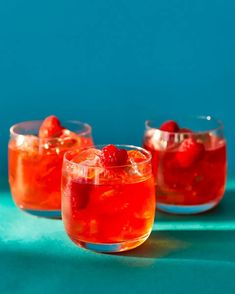 three glasses filled with raspberry punch on a blue surface