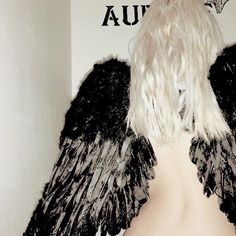 a woman with white hair and black wings on her back