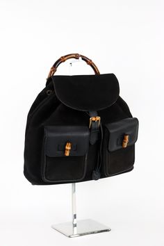 This vintage Gucci backpack is a stylish addition to any outfit. The exterior is made of high-quality leather and suede with bamboo accents, while the hardware is a beautiful gold color. The backpack has a medium size and measures 12.5 inches in width, 12 inches in height, and 4 inches in depth. It features a buckle and drawstring closure, and the handle/strap is made of brown leather and suede with a 28-inch drop. The interior is lined with satin and has a black color, making it easy to find your belongings. This product is part of the Gucci Bamboo product line and was manufactured in Italy. Get this '90s-themed backpack and add a touch of style to your accessories collection. Gucci Brown Backpack For Daily Use, Gucci Standard Everyday Backpack, 90s Gucci, 90s Backpack, Gucci Luxury Standard Backpack, Brown Gucci Standard Backpack, Vintage Brown Gucci Bag, Gucci Backpack, Gucci Bamboo