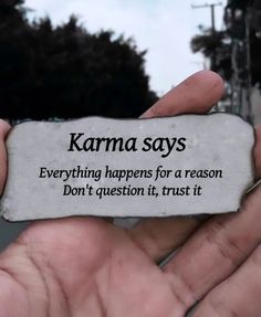 someone holding up a piece of paper that says karma says everything happens for a reason don't question it, trust it