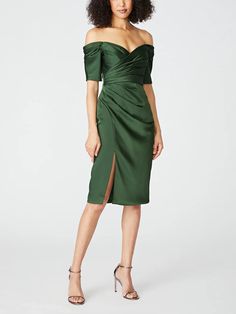 a woman wearing a green dress with a slited skirt and off the shoulder top