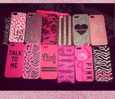 many cell phones are lined up together on a black surface with pink and gold designs