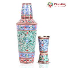 two vases sitting next to each other on a white surface with the same pattern