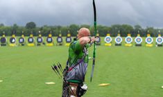 a man is practicing his archery skills on the field