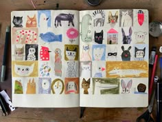 an open notebook with many cats and animals on it, surrounded by other office supplies