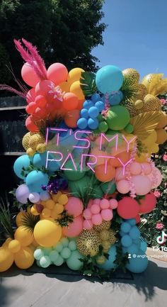 a sign that says it's my party surrounded by balloons and palm tree branches