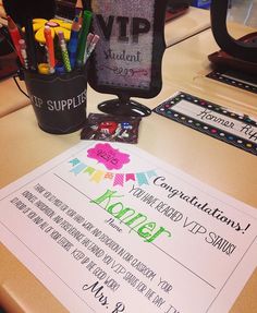 a desk with some pens and pencils on it next to a sign that says congratulations