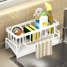 a kitchen sink caddy with cleaning products in it and a towel hanging on the rack