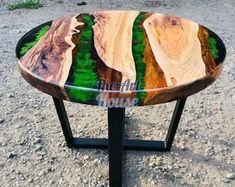 a table made out of wood and metal with green plants in the center on top