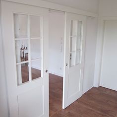 an empty room with white walls and wood flooring is shown in the foreground