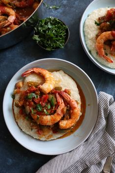 two plates with shrimp and grits on them next to a pot of white rice