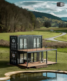 a large container house sitting on top of a lush green field