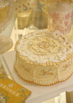 a cake sitting on top of a white table next to vases and other items