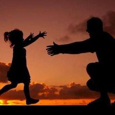 the silhouette of two people jumping into the air at sunset with their arms outstretched in front of them