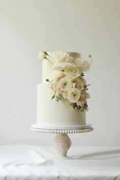 a white wedding cake with flowers on top