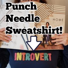 a woman holding up a book with the words punch needle sweatshirt in front of her face