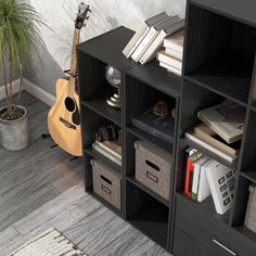 a black bookcase with books, a guitar and other items on it next to a potted plant