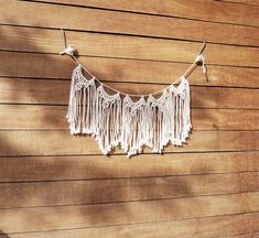 there is a string with tassels hanging on the side of a wooden wall