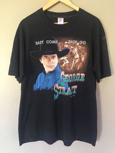 a black t - shirt with an image of george strait on it