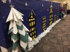 christmas decorations are lined up on the wall in front of a blue backdrop with buildings