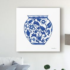 a blue and white vase sitting on top of a table next to a lamp in a living room