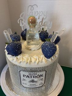 a cake decorated with strawberries and a bottle of patron