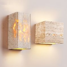 two light fixtures mounted to the side of a wall with fire coming out of them