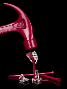 a pair of red handled hammers and nails on a black background