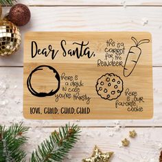 a wooden cutting board with different types of cookies on it and christmas decorations around it