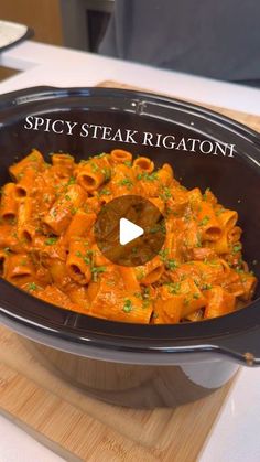 a pot filled with pasta and sauce on top of a wooden cutting board