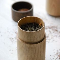 two wooden containers filled with tea on top of a table