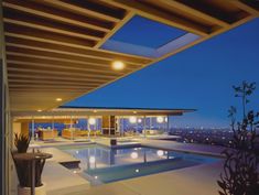 an indoor swimming pool in front of a large window with the city lights visible at night