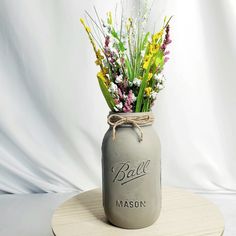 a mason jar filled with wildflowers and grass