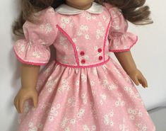 a doll with brown hair wearing a pink dress