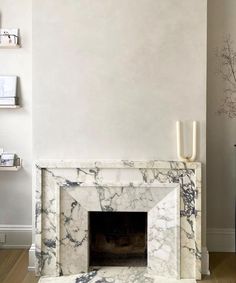 a marble fireplace in a living room with white walls