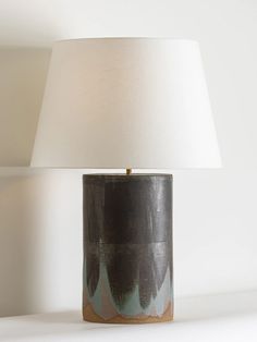 a lamp that is on top of a table next to a white wall and floor