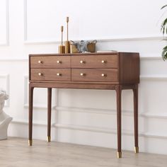 a wooden dresser sitting on top of a hard wood floor next to a white wall