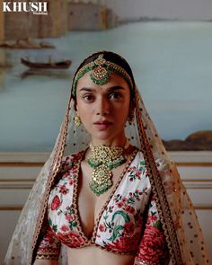 a woman wearing a bridal outfit in front of a painting