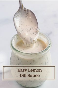 an easy lemon dill sauce in a glass jar with a spoon sticking out of it